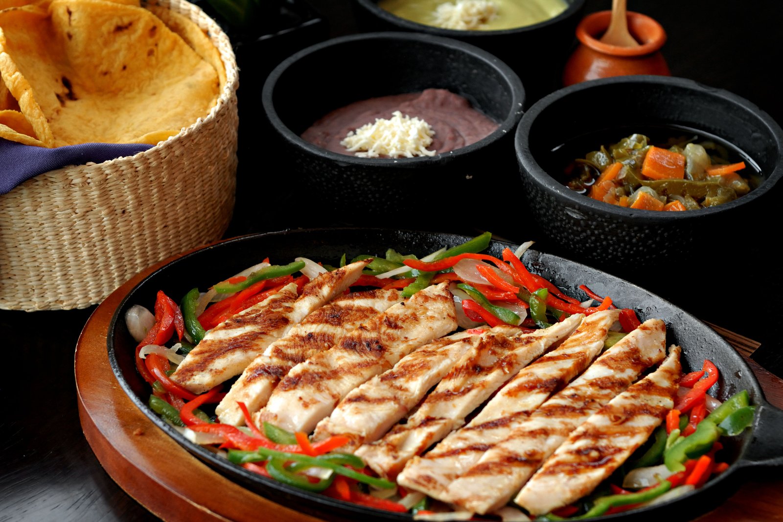 Fajitas a la parrilla con guarniciones y salsas